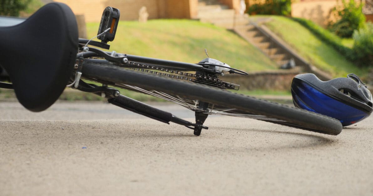 a-bicycle-lays-on-the-sidewalk-with-the-wheels-spinning-after-an-accident-as-traffic-p-SBI-350705084 - Attorneys.Media - Legal Expert Interviews & Trusted Advice